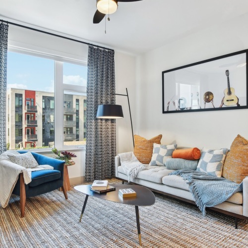 Living Room Dog-Friendly Luxury Apartments in Midtown Sacramento, CA - Press at Midtown - Living Room with a Ceiling Fan, Wood-Style Flooring, and a Spacious Window